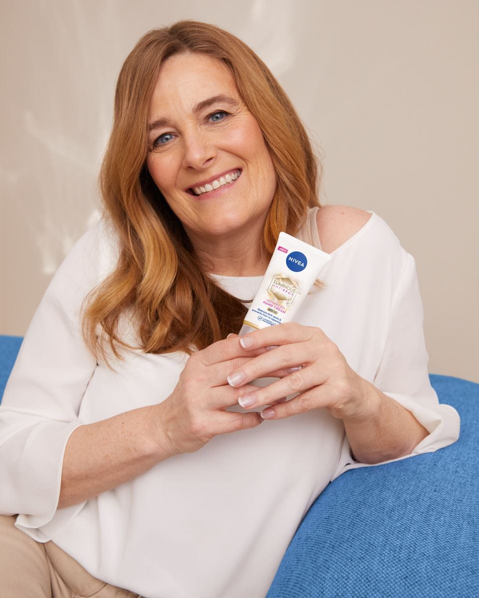 donna con in mano una crema mani Nivea Luminous630 Antispot Advanced